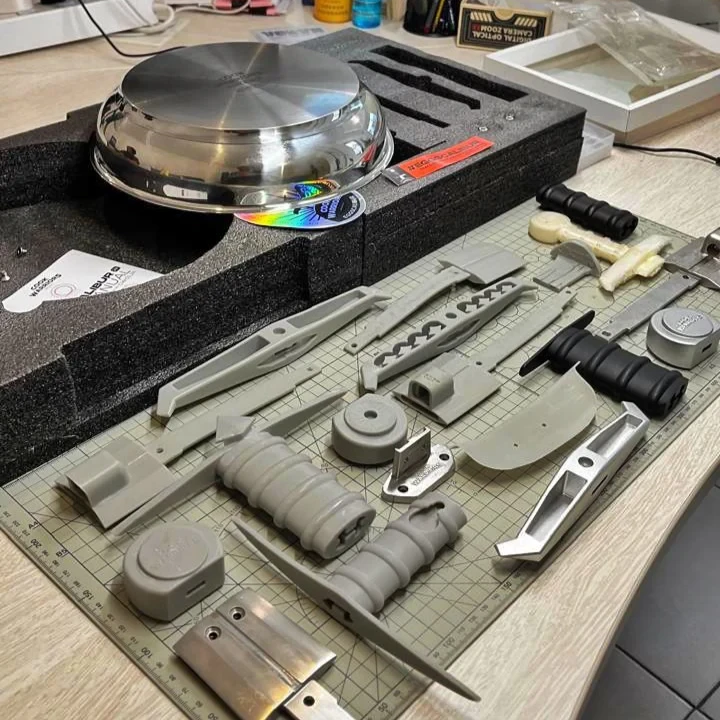 Eggscalibur sword handle prototype parts laid out during development — grip, guard, pommel and blade as separate engineered pieces before assembly