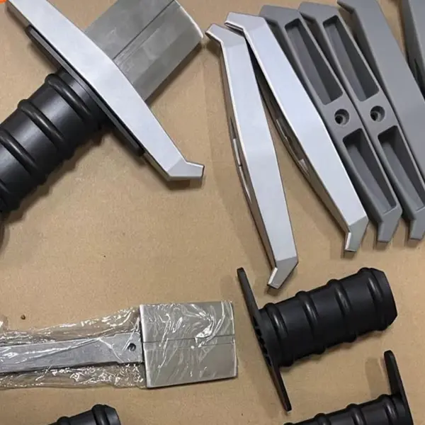 Eggscalibur sword pan handle components — stainless steel crossguards and ergonomic POM grips ready for assembly